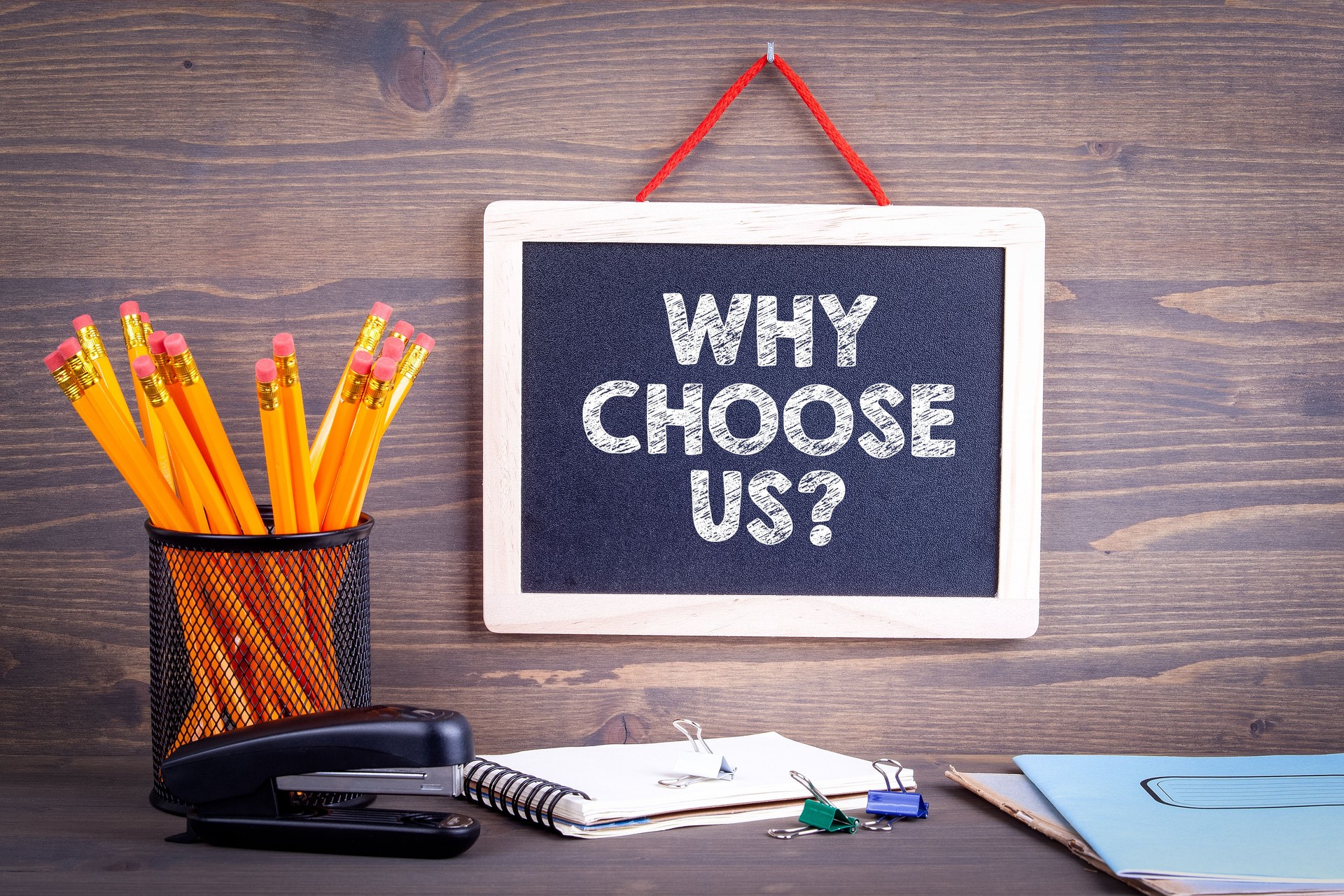 Why choose us? Chalkboard on a wooden background.